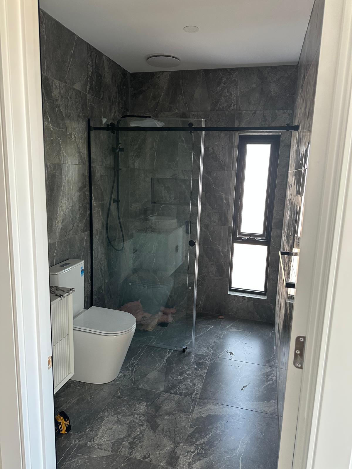 Minimalist ensuite with black hardware and window feature